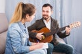 Guitar tutor helping client learn instrument