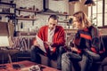 Guitar tutor holding sheet music book while teaching student