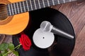 Guitar, vinyl record, microphone and rose.