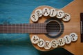 Guitar on wood with words: PRAISE and WORSHIP