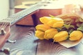 Guitar, yellow tulips, musical page