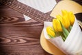 Guitar, yellow tulips, musical page