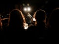 Guitarist in a concert. View behind people's silhouettes.