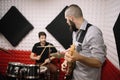 Guitarist and drummer playing in soundproof studio