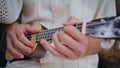 Guitarist hands touching strings playing ukulele at street closeup. Unknown man Royalty Free Stock Photo
