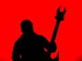 Guitarist with a Heavy Metal Pointed Guitar with Horned Headstock on Red Background Royalty Free Stock Photo