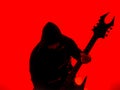 Guitarist with hood and a pointed Heavy Metal guitar with horned headstock on red background Royalty Free Stock Photo