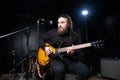 Guitarist man plays an electric guitar Close-up at studio Royalty Free Stock Photo
