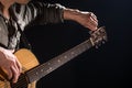 Guitarist, music. A young man plays an acoustic guitar on a black isolated background