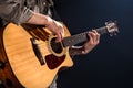 Guitarist, music. A young man plays an acoustic guitar on a black isolated background