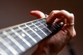 Guitarist playing a chord on a guitar fretboard close up