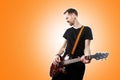 The guitarist plays the electric guitar on orange background