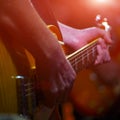 The guitarist plays the guitar in the spotlight. Hands of a Guitar player playing the guitar. Low key Royalty Free Stock Photo