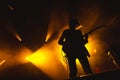 Guitarist plays solo. silhouette of guitar player in action on music stage. popular music rock band performs on stage Royalty Free Stock Photo