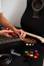Guitarist trims new strings with pliers during a classical guitar restringing process. Cutting Guitar Strings with Pliers Royalty Free Stock Photo