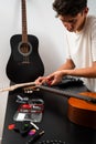 Guitarist trims new strings with pliers during a classical guitar restringing process. Cutting Guitar Strings with Pliers Royalty Free Stock Photo