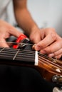 Guitarist trims new strings with pliers during a classical guitar restringing process. Cutting Guitar Strings with Pliers Royalty Free Stock Photo