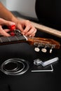 Guitarist trims new strings with pliers during a classical guitar restringing process. Cutting Guitar Strings with Pliers Royalty Free Stock Photo