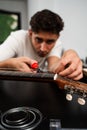 Guitarist trims new strings with pliers during a classical guitar restringing process. Cutting Guitar Strings with Pliers Royalty Free Stock Photo