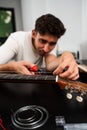 Guitarist trims new strings with pliers during a classical guitar restringing process. Cutting Guitar Strings with Pliers Royalty Free Stock Photo