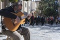 Guitarist under a tree, next to the door of the Church of the Sa