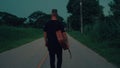 guitarist is walking on the road