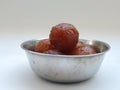 Gulab Jamoon or Jamun in a Steel, Green Color Plastic Cup and Spoon isolated on white Background Royalty Free Stock Photo