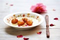 gulab jamun on white plate with rose petals Royalty Free Stock Photo