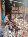 Stock photo of 40 to 50 aged Indian vendor sitting at his shop and selling colorful ,designer