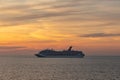 Gulf of Mexico - April 5, 2020: Shot of Carnival Valor anchored at sea. Beautiful sunset orange sky in the background and calm