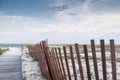 Fence on beach with natural vegetation and sand Royalty Free Stock Photo