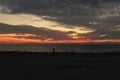 Orange Gulf of Mexico sunset with pedestrian silhouette on beach