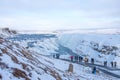 GULLFOSS, ICELAND - March 4, 2020: Tourists at the observation deck look at Gullfoss waterfall in Iceland