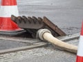 Gully cover with fire hose and Pylon Royalty Free Stock Photo