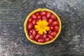 Gumi Loss Multicolor Berry in a wicker bucket with a bright yellow flower on a wooden bench