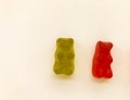 Gummy bears of bright colors on a pink matte background. green and red transparent bear. delicious appetizing candies of an