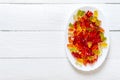 Gummy bears in a plate on a white wooden background