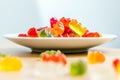 Gummy bears on a white plate and wooden table Royalty Free Stock Photo