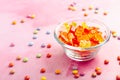 Gummy candy, colorful jelly bears in a bowl on pink background