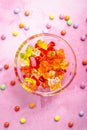Gummy candy, colorful jelly bears in a bowl on pink background