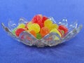 Gummy candy in a plate a blue background lateral view Royalty Free Stock Photo