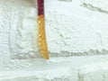 Gummy worm on the background of a white brick plastered wall. appetizing gelatinous candies. worms for halloween. delicious and Royalty Free Stock Photo