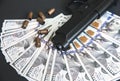 Gun with bullets lying on the table. Money on black background. Criminal problems. Dollars