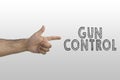 Gun control concept. Inscription gun control on whiteboard with man`s hand showing pistol gesture Royalty Free Stock Photo