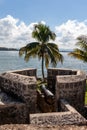 Gun, defense cannon at the old fortress tower, the bay of the caribean sea. San Felipe Castle in Livingstone Guatemala. Palms and