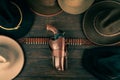 Gun with holster and gunbelt with old west hats on table. Top view Royalty Free Stock Photo