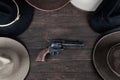 Gun with old west hats on table. Top view Royalty Free Stock Photo