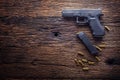 Gun pistol. 9 mm pistol gun and bullets strewn on the rustic oak table Royalty Free Stock Photo