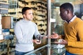 Gun seller offers man to buy pistol at gun store Royalty Free Stock Photo