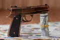 Gun and Stack of Money lying on the hryvnia on a wooden table. Drug use, crime, addiction and substance abuse concept on wooden Royalty Free Stock Photo